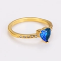 Macro shot of gold ring with heart-shaped blue stone and small zircon side accents - Gold (Blue Zirconia)