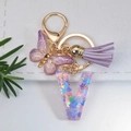 Purple resin letter V keychain with glitter, butterfly charm and silk tassel details - Letter V