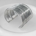 Makroaufnahme der silbernen Mehrschicht-Drahttextur auf einem breiten offenen Armreif - Silbernes Mehrlagiges Linien Offenes Armband