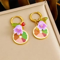 Goldene Ohrringe mit lila Maiglöckchen und Zitronen-Anhängern auf einer Schmuckbox - Lila Maiglöckchen & Zitronenscheiben Stil (E6246)