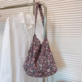 Detail van vintage navyblauwe hobo-tas met bloemenpatroon hangend aan een rek - Roze Paars Klein Bloemetje
