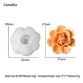 Detailweergave van camellia siliconen mal met afgewerkte oranje kaars en bloemtextuur - Camellia