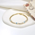 Dettaglio del bracciale dorato con ciondoli occhio blu e pietre di zircone incastonate - Malocchio Blu Scuro (221116G-A-3)