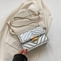 Borsa a tracolla trapuntata argento con catena dorata su blazer beige - Argento