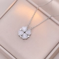 Silver four-leaf clover necklace with white heart-shaped stones on champagne jewelry box - Silver