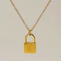 Close-up of gold padlock pendant featuring a gothic letter D on a fine chain - Letter C Style
