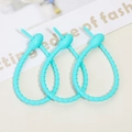 Detail view of three Tiffany blue silicone cable ties on a minimalist background - Lake Blue