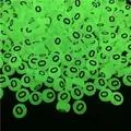 Macro shot of luminous flat round acrylic beads glowing in green with black letter O print - Letter O (100Pcs/Pack)