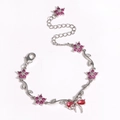 Silver flower bracelet with pink zircon bow and magenta stones in a curved display - Red White Gold