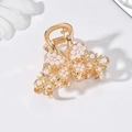 Close-up of a golden butterfly hair claw clip with white pearls on a white background - Gold Butterfly