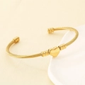 Dettaglio di un ciondolo a cuore dorato su un bracciale rigido a cavo intrecciato oro - Oro (KB191184-XY)