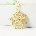 Golden flower keychain with rhinestone edges and cream enamel finish on metallic chain - White