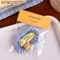 Set aus hellblauem Scrunchie und gelber Bärenspange in eleganter Geschenkverpackung - Honigtopf Bär Haargummi Kombination