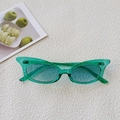 Detail view of stylish green oval sunglasses with translucent resin frame and cyan lenses - Pale Green