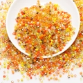 Macro shot of assorted warm-toned square glass beads for DIY jewelry and hair accessories - Yellow Series