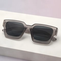 Macro detail of thick square gray sunglasses on a minimalist platform with gradient background - Translucent Grey Frame Grey Lens
