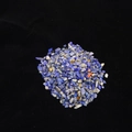 Macro shot of natural blue lapis lazuli crushed stones with fine textures on black velvet - 100 g / Lapis Lazuli