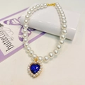 Close-up of pearl pet necklace with blue heart crystal pendant and golden setting - Sapphire Blue