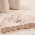 Macro shot of transparent resin square ring on a stone base showcasing thick modern design - Clear