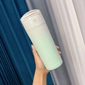 Detail of gradient green coffee tumbler with non-slip vertical texture and flip lid - 500ml / Green