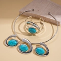 Detailed shot of bohemian resin turquoise necklace and open bangle on stone props - Silver