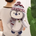 Cute plush penguin backpack with grey fur and red knitted hat worn by a model - 40cm Backpack / Gray