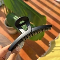 Detail of matte black 13.5cm butterfly hair claw clip with cutout design in hand - Matte Black