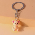 Primer plano de llavero de oso beige con orejas de purpurina rosa en soporte de diseño - Color Piel