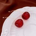 Vista macro de pendientes de cereza en resina sobre plato blanco con seda oscura - Estilo Rojo en Forme de Cereza (13#银针-金色-红色)