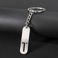 Polished silver stainless steel keychain featuring a minimalist hollow letter T cutout - Letter T