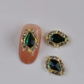 Golden nail art charm with green teardrop rhinestone and small crystals on nude nail - Gold Base Dark Green Waterdrop