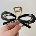 Vue détaillée d'une pince à cheveux vintage avec nœud noir et cadre en métal doré - Pince 11.5cm / Noir