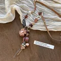 Vue détaillée de pendentifs fleurs bohèmes avec médaille Believe et perles variées - 12# Collier-Café (Fleur en Tissu/Tag Believe)