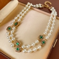 Close-up of double-layer pearl necklace with green gemstone and gold accents in jewelry box - Double Layer Necklace (Gold-White-Green Gem)