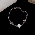 Macro shot of silver clover bracelet with white mother of pearl and zircon details - Silver
