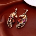 Macro shot of vintage gold horse head earrings with red crystal and sparkling rhinestones - S925 Silver Pin Ancient Gold Horse