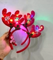 Detail of red plush reindeer headband with festive snowflake decor and glowing LED lights - Glowing Green Leaves Reindeer Antler Headband