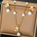 Détail d'un collier papillon doré et boucles d'oreilles perles dans une boîte à bijoux - Style Perle Papillon (N2965)