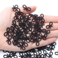 Hand holding black bow-shaped resin beads for DIY handmade jewelry crafts - Black