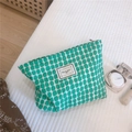 Détail d'une trousse à maquillage géométrique verte avec étiquette Time to Party sur tissu - Vert
