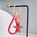 Close-up of pink rhinestone starfish pendant with braided leather keychain and gold details - Starfish + Heart Strap / Deep Pink