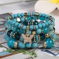 Boho-Mehrlagenarmband mit türkisfarbenen Perlen und goldenem Schmetterlingsanhänger - Seeblau