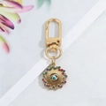 Detail of golden evil eye keychain with colorful rhinestones and sunburst design - Colorful Rhinestone Rotating Round Eye