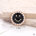 Detail eines 2,5 cm gold-lächelnden Schuhanhängers mit Perlenrand auf einem Stein - Smiley / Emaille Perle Smile Face Schwarz
