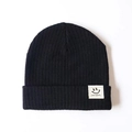 Classic black knitted baby beanie with ribbed texture and a smiley face woven label - One Size / Black