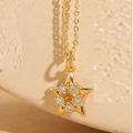 Detailed view of a gold star necklace pendant featuring five sparkling white zircons - Five-pointed Star Gold