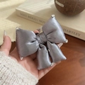 Elegant silver grey silk bow hair tie with sparkling rhinestones in hand presentation - Purple