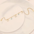 Detail of gold chain bracelet with white enamel clover and blue bead charms on marble - Four-Leaf Flower Enamel Style(9#)