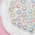 Macro shot of iridescent round acrylic beads with colorful rainbow finish on ceramic plate - White