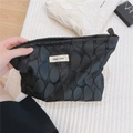 Vue macro d'une pochette géométrique en toile noire avec étiquette simple wish tissée - Noir